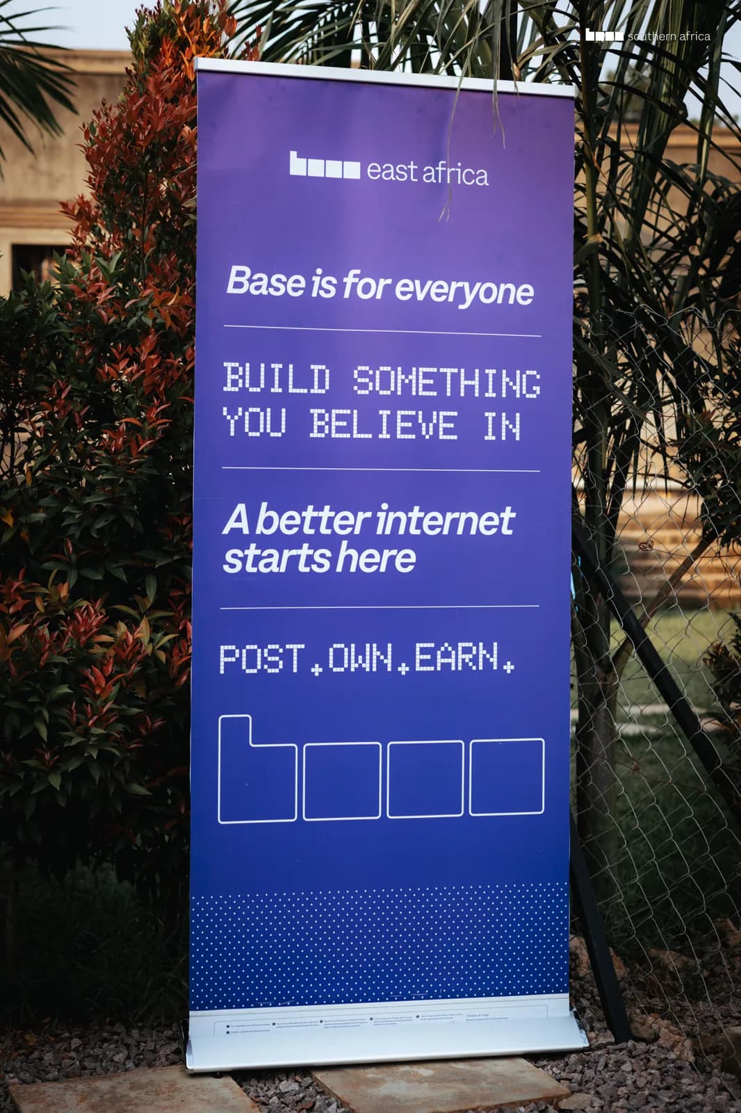 Base east africa roll-up banner reading “Base is for everyone — build something you believe in — a better internet starts here — Post. Own. Earn.”