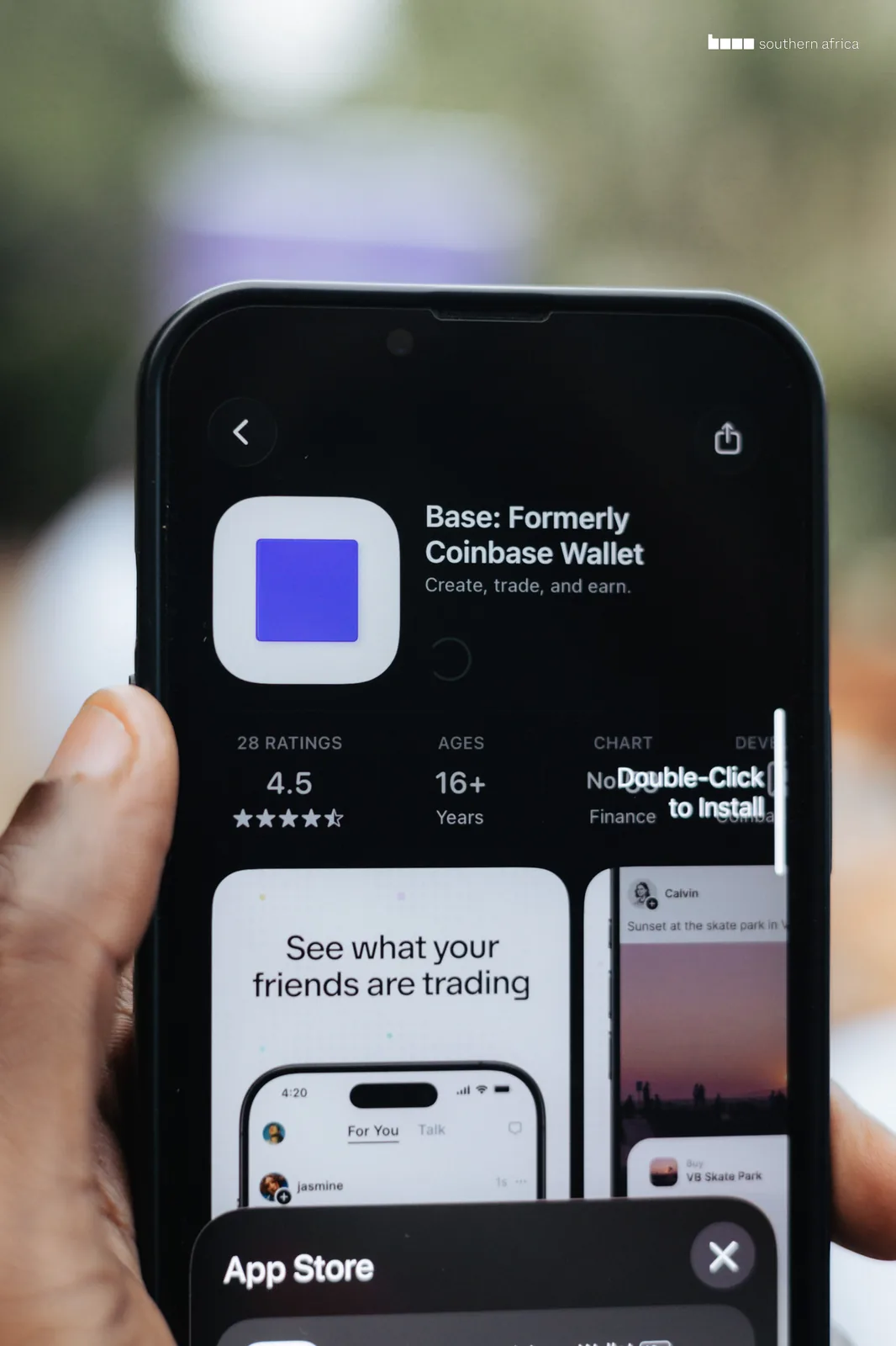 A hand holding a phone showing the Base app listing on the App Store