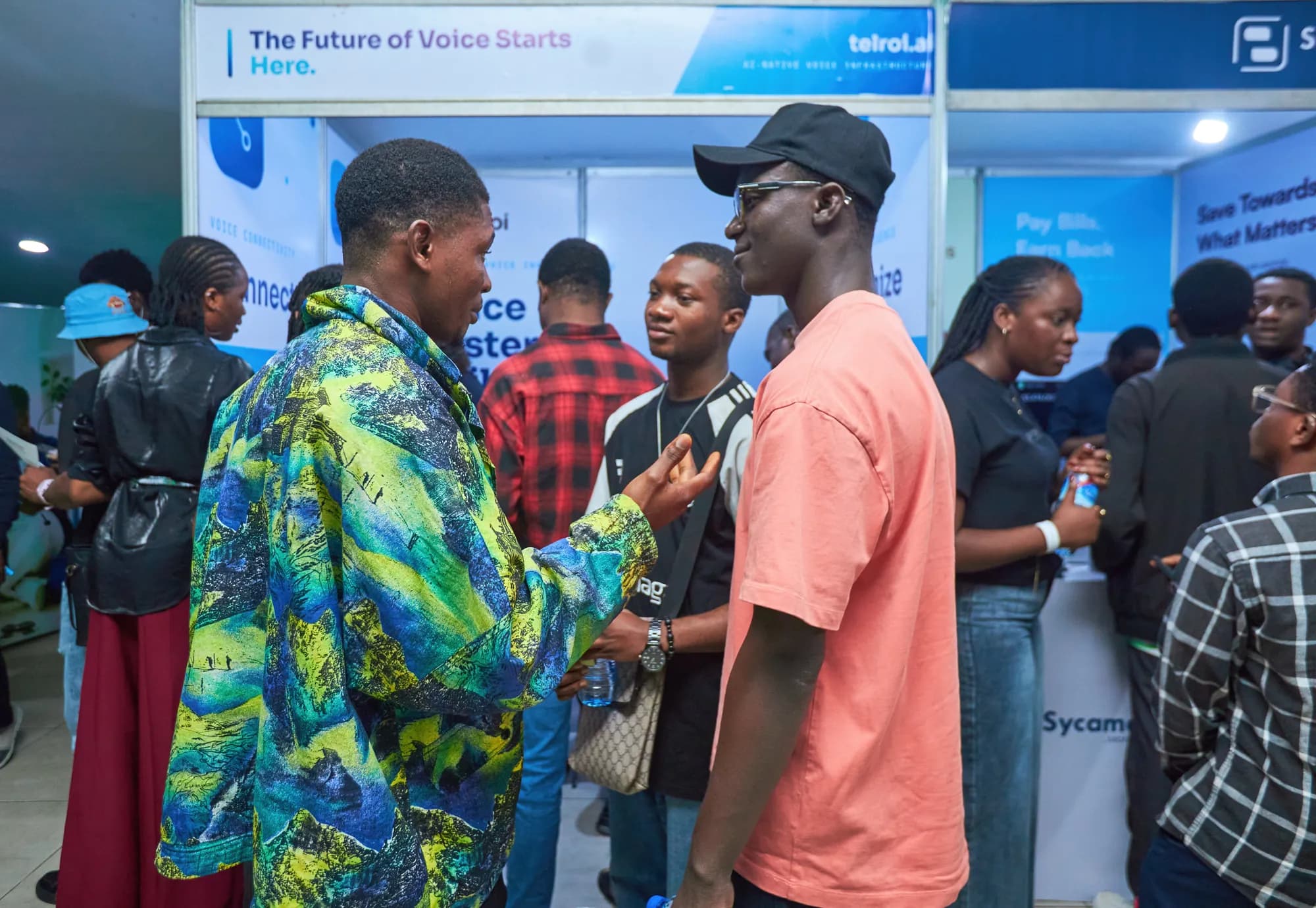 Attendees talking on the exhibition floor between sponsor booths