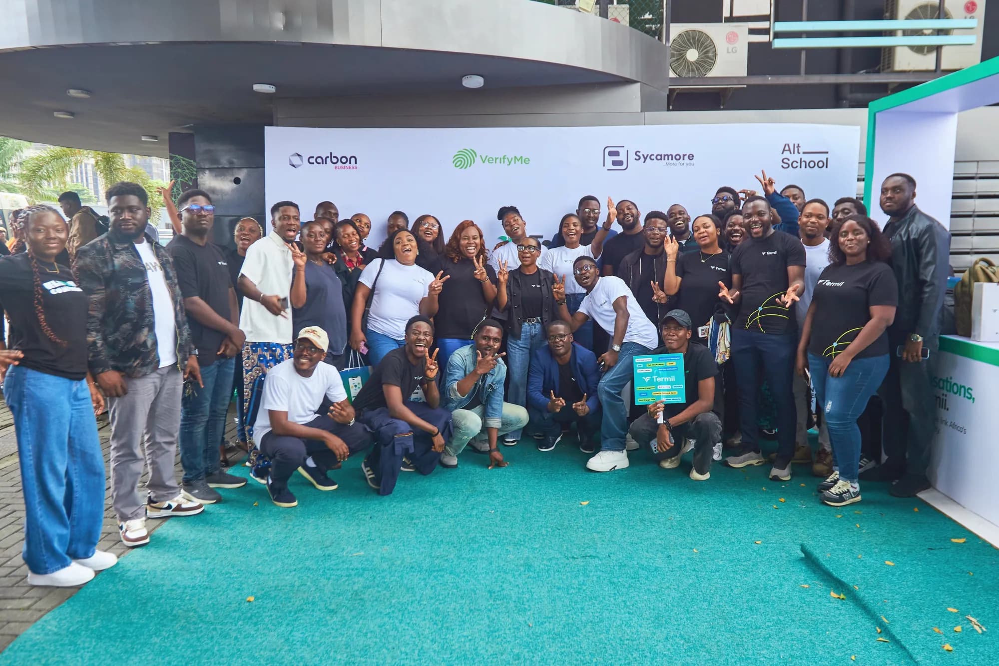 A large group photograph of the team outside the venue